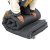 Image showing the Double Self-Inflating Foam Camping Air Mattress being folded by a person with their knees on the mattress.