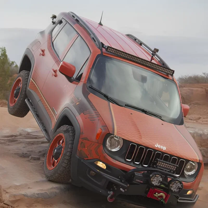 Front view image of an orange Jeep Renegade lifted 40mm, on the rocks.