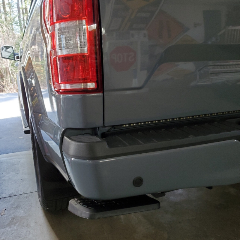 Rear view of the Toyota Hilux 2015+ Retractable Rear Bumper Steel Step installed and folded.