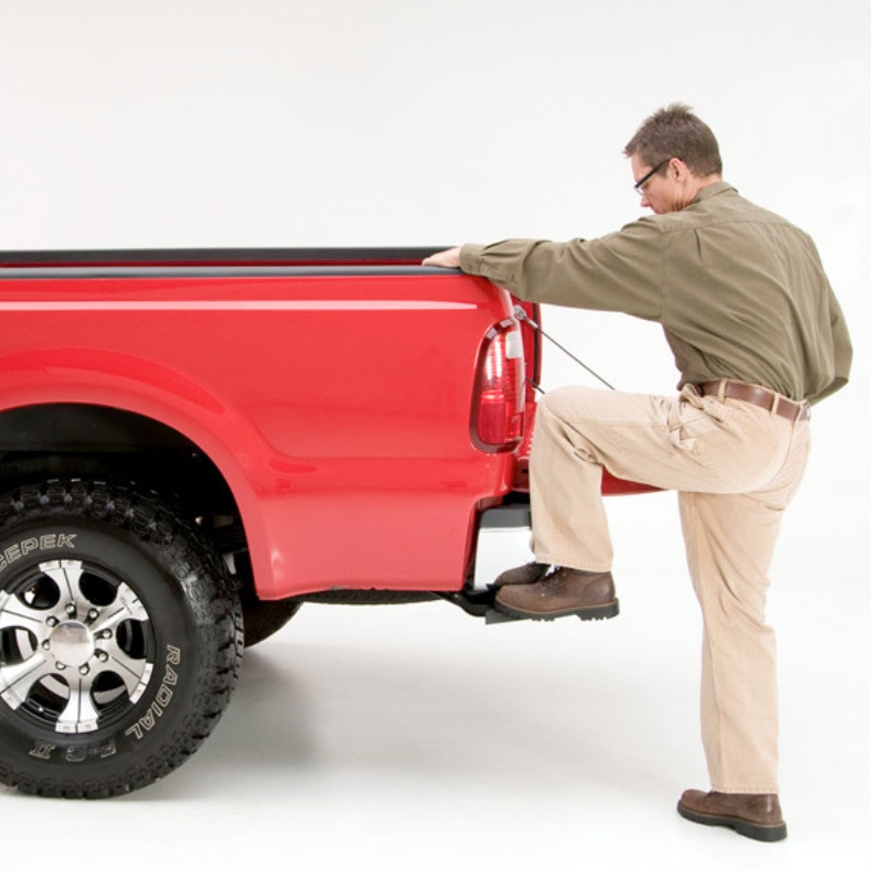 Image showing a man stepping on the Toyota Hilux 2015+ Retractable Rear Bumper Steel Step