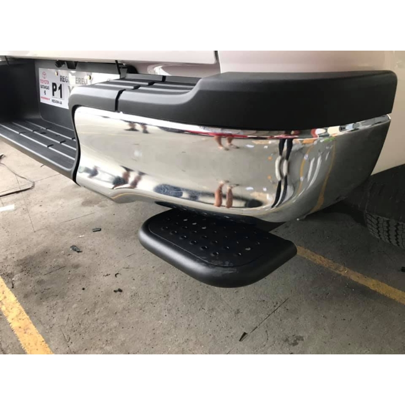Rear close-up image of a pickup truck with the Toyota Hilux 2015+ Retractable Rear Bumper Steel Step installed and folded.